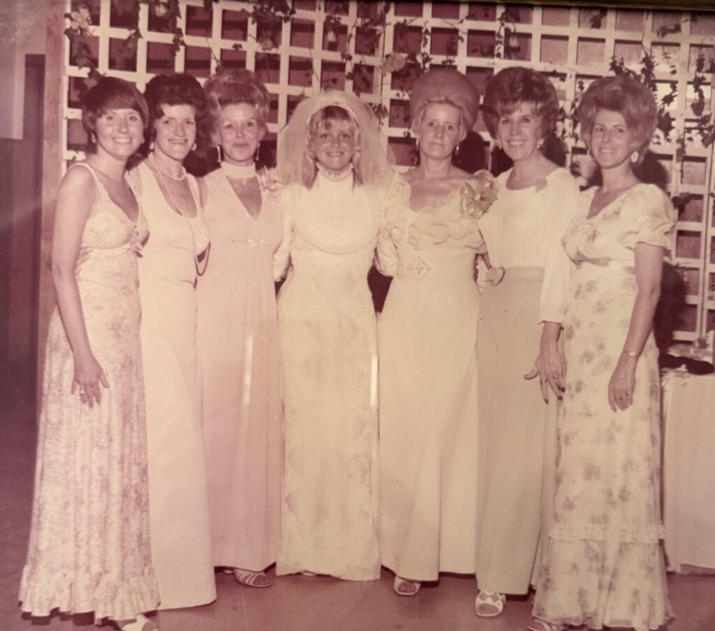 vintage photo of young woman on wedding day surrounded by her mom and aunts